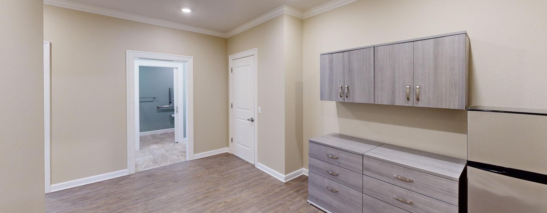 a room with a wood floor and cabinets